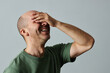 © Seventyfour - Candid portrait of mature bald man laughing emotionally with eyes closed against pale grey background