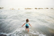 © Maria Manco/Stocksy - Girl stands at beach with open arms