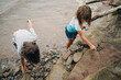 © Maria Manco/Stocksy - Kids play with rocks in water at beach