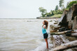 © Maria Manco/Stocksy - Girl stands at beach with open arms