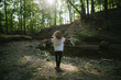 © Maria Manco/Stocksy - Girl stands with open arms in the middle of the woods