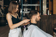 © Alina Hvostikova/Stocksy - Professional hairstylist trimming hair of bearded client