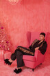 © Liliya Rodnikova/Stocksy - Fashionable young woman relaxing in pink armchair - Xmas mood
