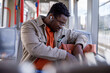 © Jovo Jovanovic/Stocksy - Man looking inside his bag while sitting in tram and listening music