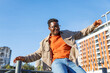 © Jovo Jovanovic/Stocksy - Carefree man sitting on fence and having fun outdoors in the city