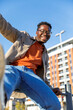 © Jovo Jovanovic/Stocksy - Excited man holding fence and having fun outdoors in the city