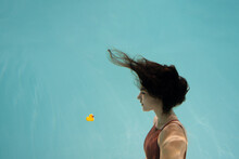 Brunette Model Posing Underwater With Toy Duck