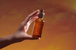 © Marc Tran/Stocksy - hand holding bottle with pipette and drop of oil