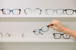 © VICTOR TORRES/Stocksy - Anonymous woman choosing glasses in optic shop