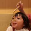 © Pansfun Images/Stocksy - Cute little girl eating noodle