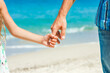© Kostia - A Hands of a happy parent and child on the seashore on a journey trip in nature