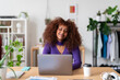 © Studio Marmellata/Stocksy - Smiling Eritrean woman browsing computer in apartment