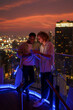 © Jovo Jovanovic/Stocksy - Tourists discussing plans on rooftop at night
