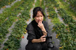 © ChaoShu Li/Stocksy - Asian girl practice photography in strawberry field