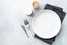White Plate And Cutlery On Stone Table. Table Setting, Flat Lay Image.