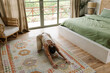© Mihajlo Ckovric/Stocksy - Young woman doing yoga in bedroom