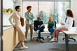© BONNINSTUDIO/Stocksy - Group of diverse coworkers talking in workspace
