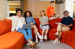 © BONNINSTUDIO/Stocksy - Cheerful diverse colleagues sitting on couch in office