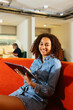 © BONNINSTUDIO/Stocksy - Smiling woman with tablet looking at camera