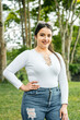 © Mauricio Toro - portrait of beautiful latin woman standing in the middle of a park, looking very happy in front of her.