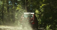 Vintage Van Drives Through Dusty Forrest Road With Bike Rack On The Back