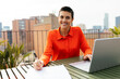 © BONNINSTUDIO/Stocksy - Smiling woman taking notes sitting on terrace building