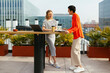 © BONNINSTUDIO/Stocksy - Smiling women working on table in a terrace building