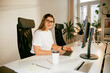 © Artem Podrez/Stocksy - Film Photo Of A Business Woman Working In A Bright Office