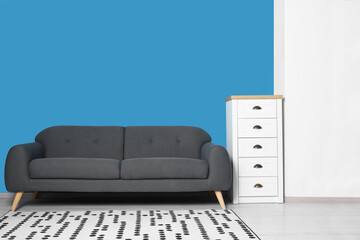 Canvas Print - Stylish living room interior with comfortable sofa and chest of drawers