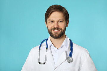 Canvas Print - Happy doctor or medical assistant (male nurse) with stethoscope on turquoise background