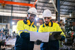 © chokniti - Production engineers in safety wear are assisting adjusting and maintaining CNC or factory machine, Male workers technician examining control the industrial tool, professional men at work in industry