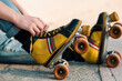 © Nano - vista desde cerca de patines de cuatro ruedas de colores, con manos de mujer acomodando cordones.
