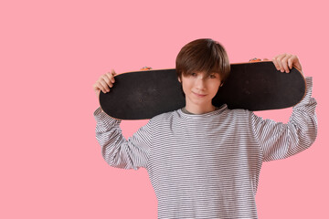 Wall Mural - Teenage boy with skateboard on pink background