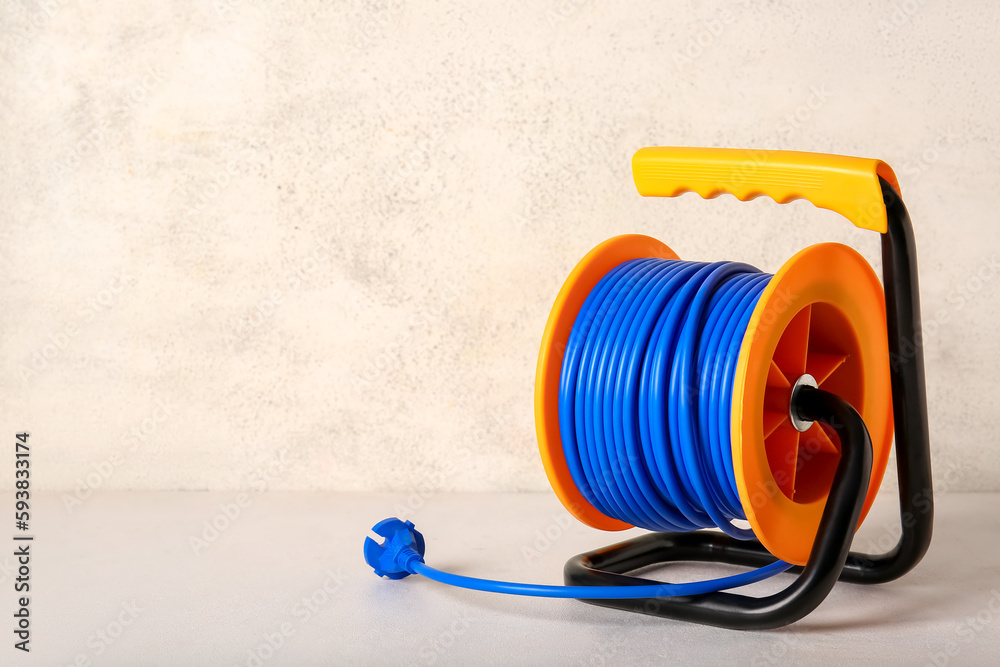 Extension electric cable reel on light background