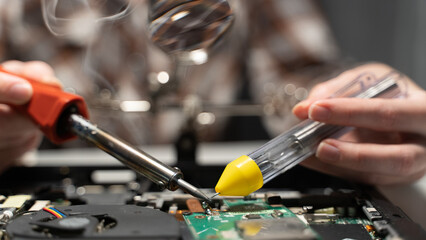 Wall Mural - the master solders the chip with a soldering iron