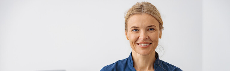 Wall Mural - Smiling doctor, ultrasound specialist looking at camera on her workplace in clinic