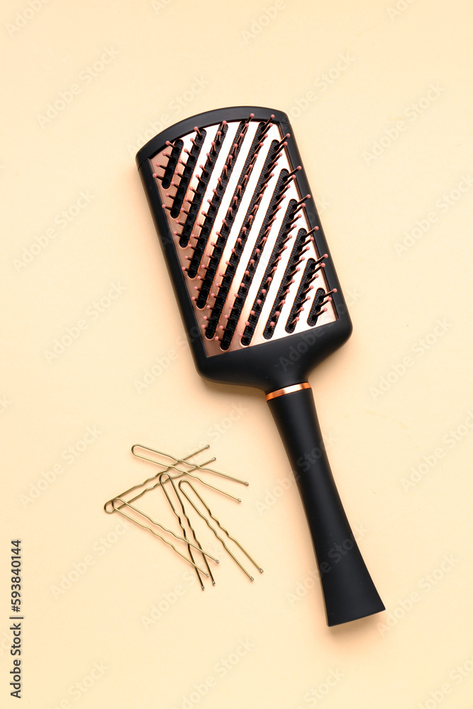 Hairpins with brush on beige background