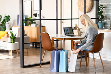 Sticker - Mature woman with new shoe and shopping bags at home