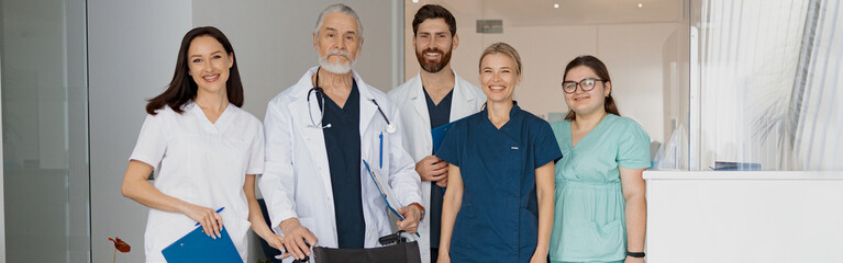 Sticker - Group of professional doctors in uniform standing in clinic hall with medical wheelchair