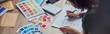 © Kostiantyn - Close up shot of working process of interior designer making notes on a blueprint, selecting color samples, sitting at the table in her office