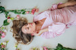 © dmitriisimakov - beautiful blonde lies in flowers in the room