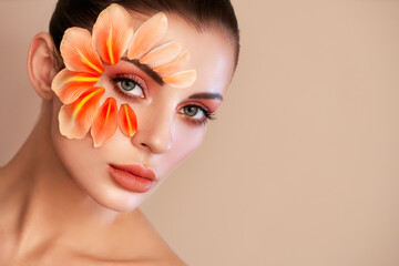 Wall Mural - portrait of beautiful young woman with makeup petals. brunette woman with luxury makeup. perfect ski