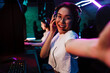 © Drobot Dean - Smiling asian girl taking selfie while playing online video game in cybersport club