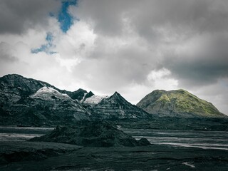 Poster - Scenic view of three snow-covered mountains in the backdrop of dark, moody clouds, Iceland