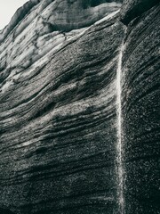 Sticker - Greyscale of a rock formation with a small stream trickling down, Katla region of Iceland