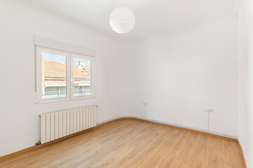 An empty small bright room with white walls and a window overlooking a neighbors house on a sunny day. The concept of housewarming in a new house. Copyspace