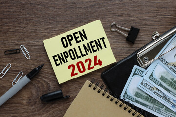 Wall Mural - open enrollment 2024. text on a sticker next to money and banknotes