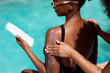 © Meeko Media - Close up of friend applying sunscreen, two Black women protecting skin in sun