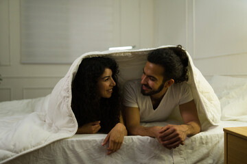 Wall Mural - Happy couple having fun under the covers in bed