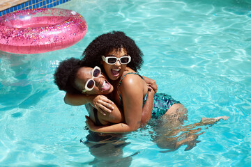 Wall Mural - Two friends cool off in the swimming pool, hugging laughing having fun